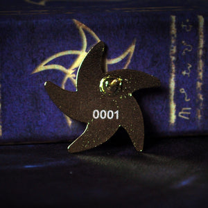 The Astral Elder Sign gold collectible pin with white enamel; back of pin